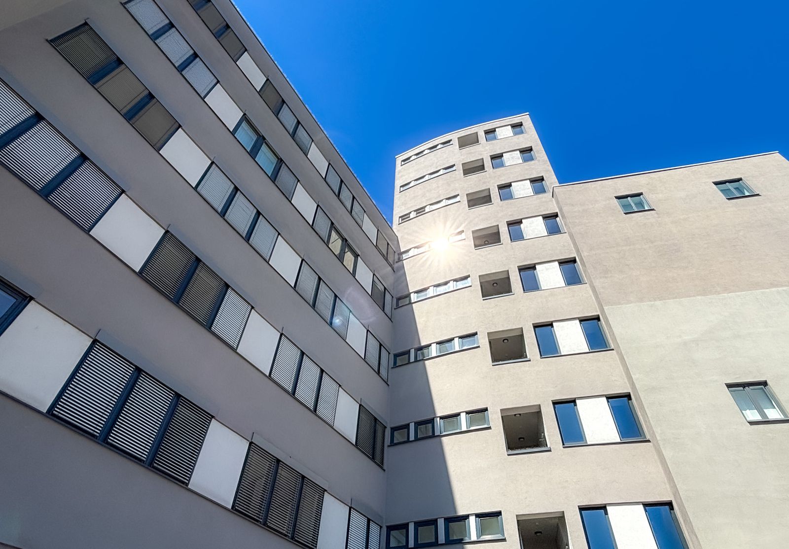 Fassade eines Bürogebäudes mit Hochhaus im Hintergrund